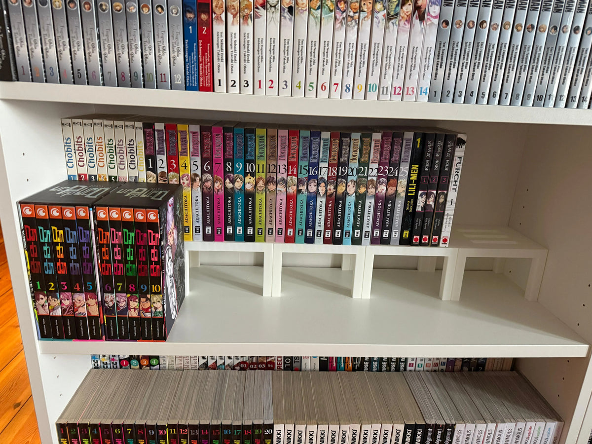 Rehausseur de livres modulable blanc imprimé en 3D, utilisé sur une étagère bibliothèque remplie de mangas colorés