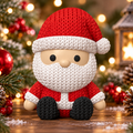 Figurine de Père Noël assis effet tricot, avec bonnet rouge, barbe blanche et bottes noires, dans un décor de Noël lumineux.